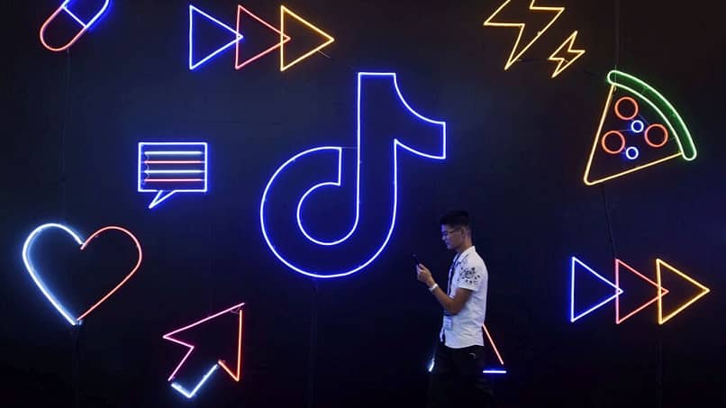 persona caminando junto al logo de tiktok